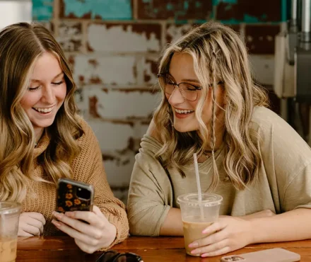 women laughing at phone