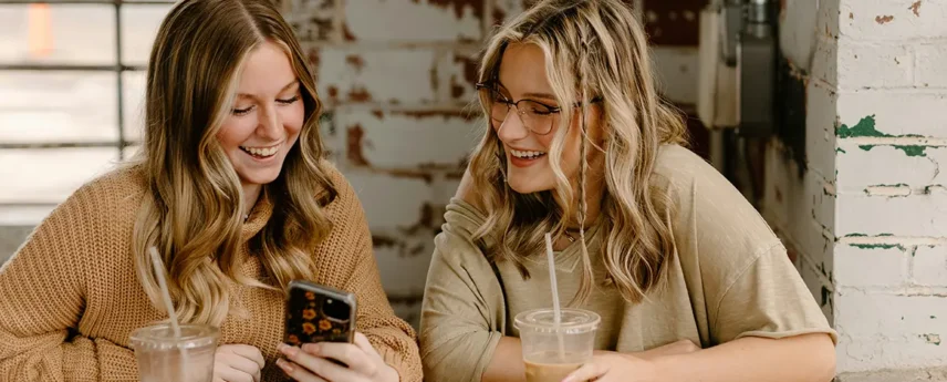 women laughing at phone